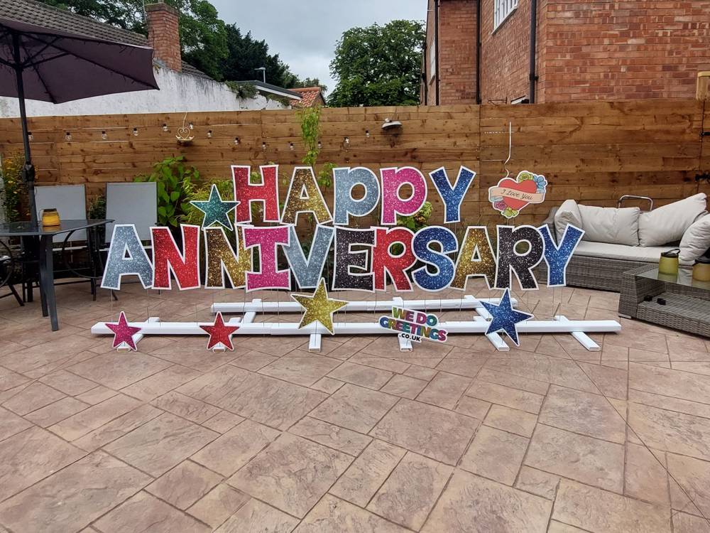 Happy Anniversary in glitter letters on a patio in a living room