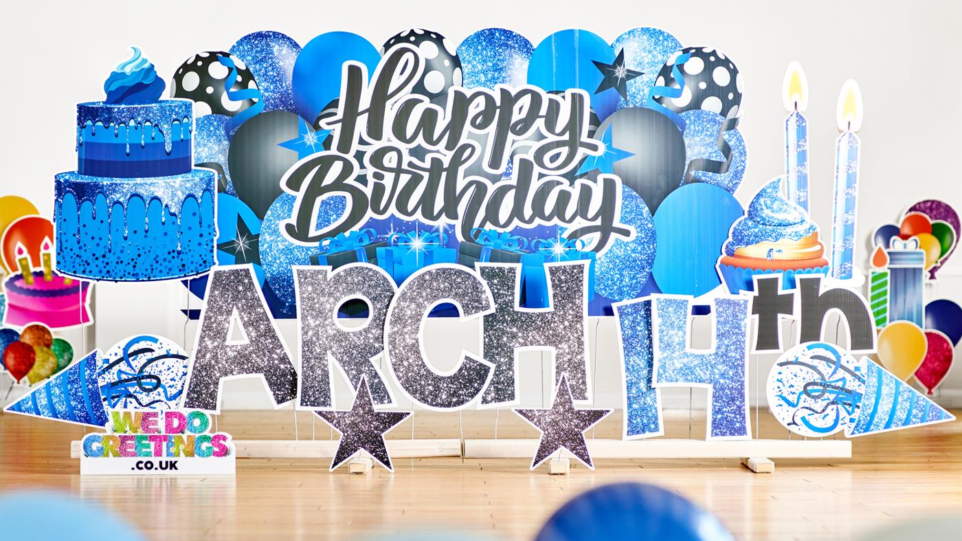 Happy Birthday backdrop in blue with the name Arch and 14th in glitter