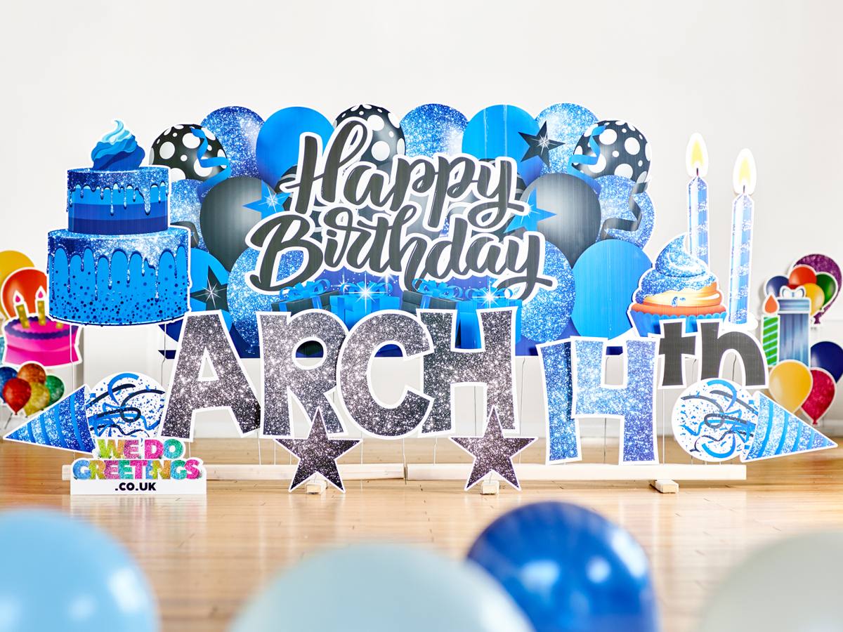 Happy Birthday Arch 14th with a blue balloon backdrop and cake accessories