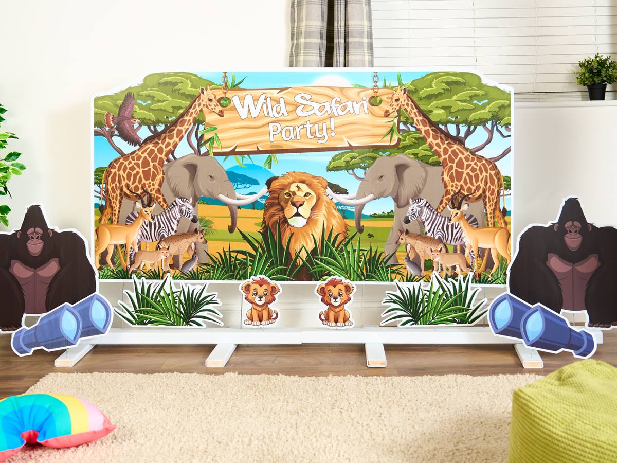 Wild Safari Party backdrop with gorilla, lion cub and binocular cut-outs in a playroom
